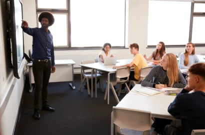 male-high-school-teacher-standing-next-to-interact-2024-10-19-01-59-21-utc